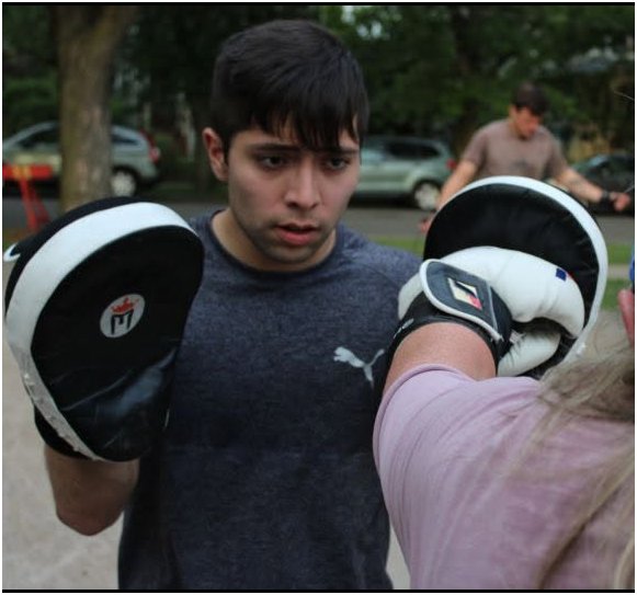 Holding focus mitts during a boxing class